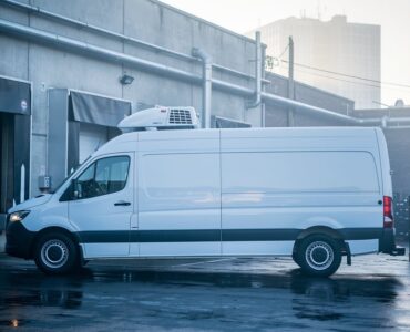 Camion frigorifique blanc en cours de chargement sur un quai de produits frais